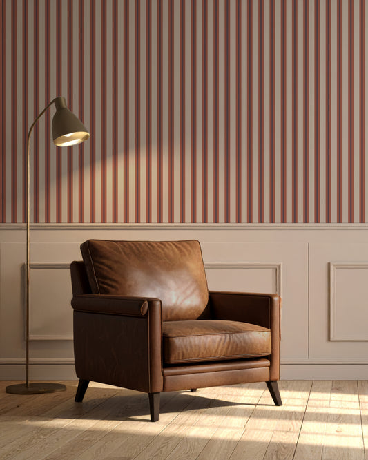 Brown leather armchair in a room with striped wallpaper and a floor lamp.