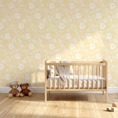 A nursery room scene with a light wood crib against a butter yellow floral wallpaper wall, with two teddy bears on the floor and a small pair of shoes nearby.