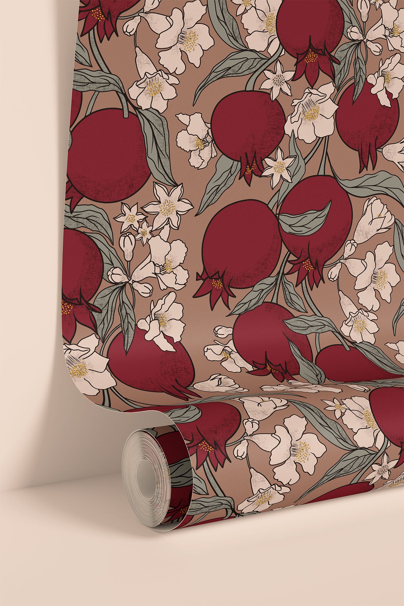 A roll of wallpaper or fabric with a repeating pomegranate and white floral pattern on a warm taupe background, shown partially unrolled against a clean cream wall.