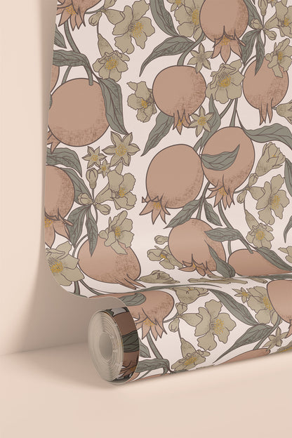 A roll of wallpaper with a botanical pattern of pomegranates, olive leaves, and cream flowers, shown partially unrolled against a warm beige background.