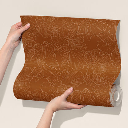  roll of cognac brown wallpaper with a light tan floral line pattern against a plain beige background.