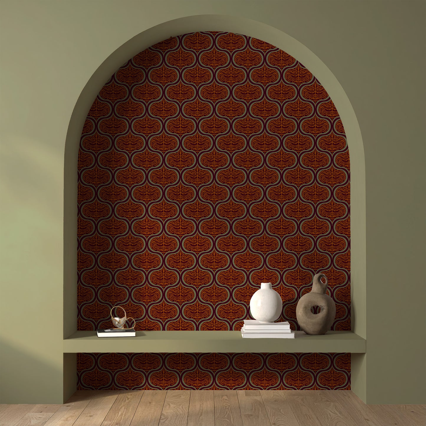 A styled interior scene showing a decorative arched alcove with a repeating terracotta and brown ornamental wallpaper pattern on the back wall, plus a built-in shelf with books and ceramic vases.