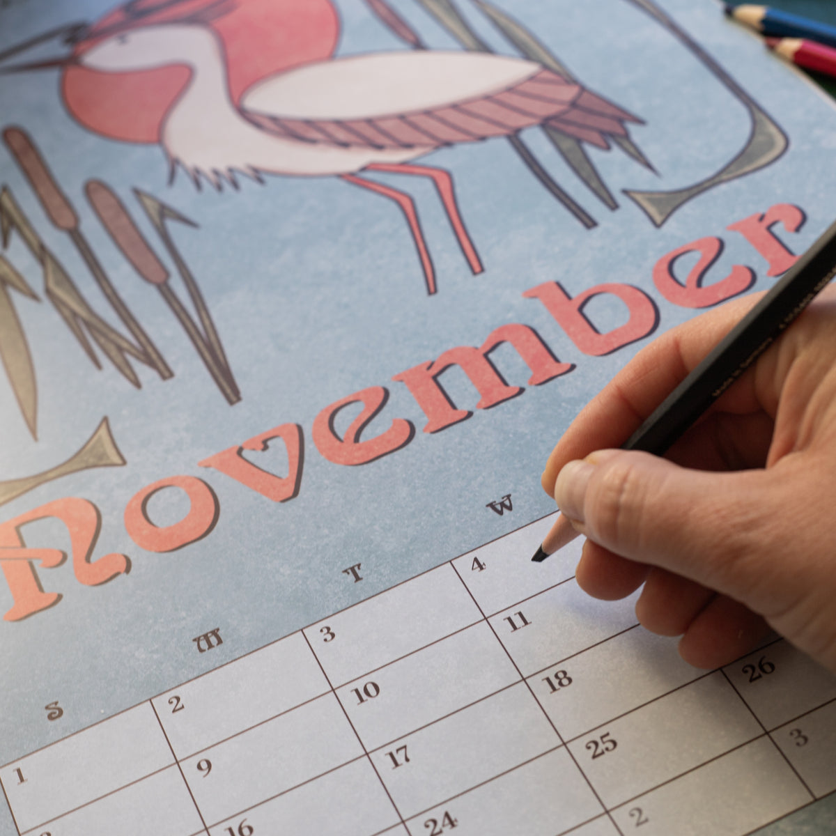 Hand writing on the November page of the Art Nouveau Garden Dreams calendar, with a crane illustration