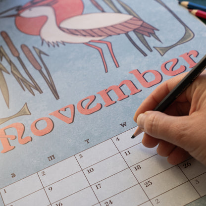 Hand writing on the November page of the Art Nouveau Garden Dreams calendar, with a crane illustration