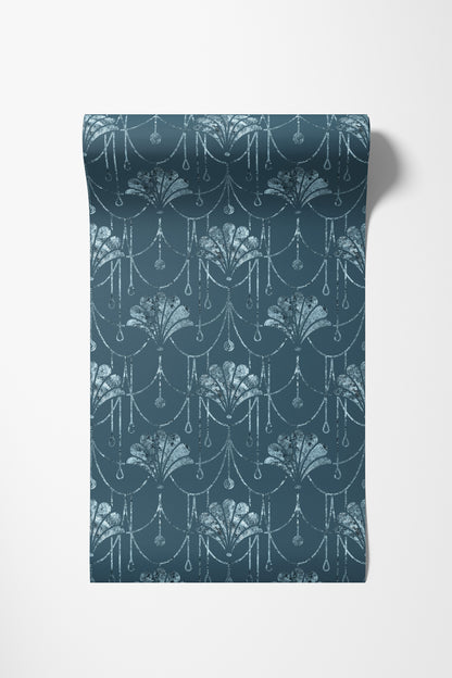 A roll of wallpaper with a repeating damask-style floral pattern in a muted teal blue and white, shown against a plain white background.
