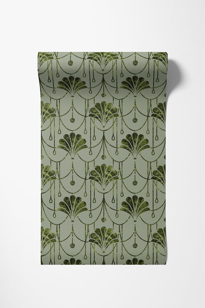 A roll of wallpaper with a repeating Art Deco fan pattern in dark olive green on a muted sage green background, shown against a plain white wall.