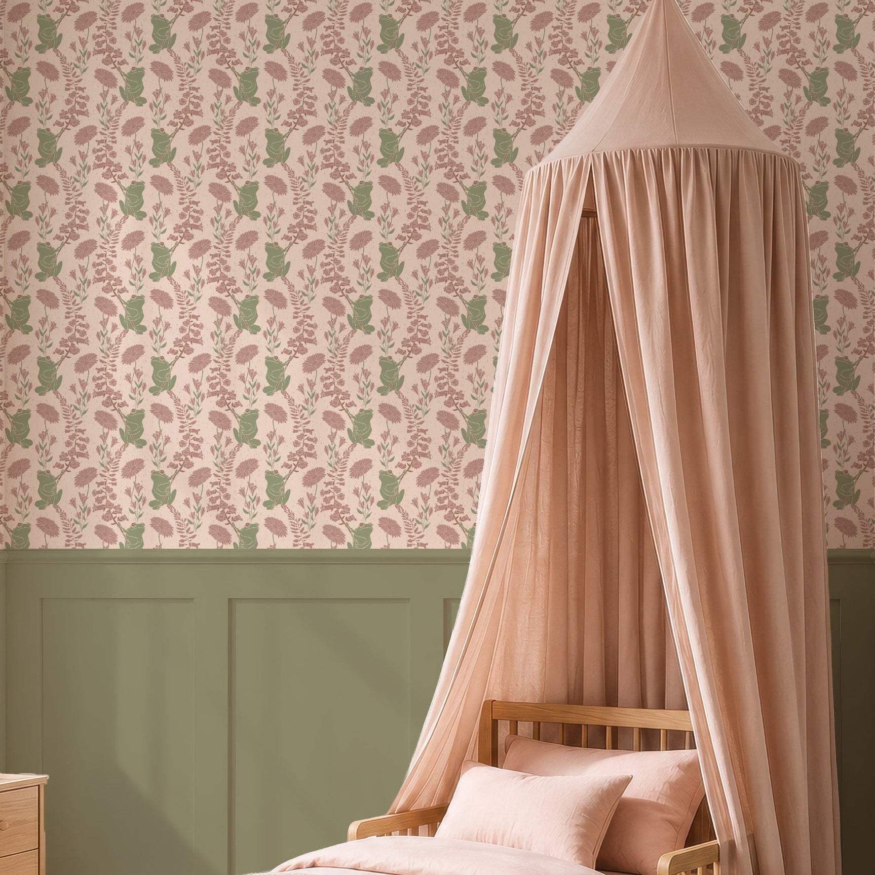 A styled children's bedroom featuring a light wood single bed with a dusty pink canopy, pink bedding, and a patterned wallpaper on the upper wall. The room has sage green wainscoting and a light wood nightstand by a window.