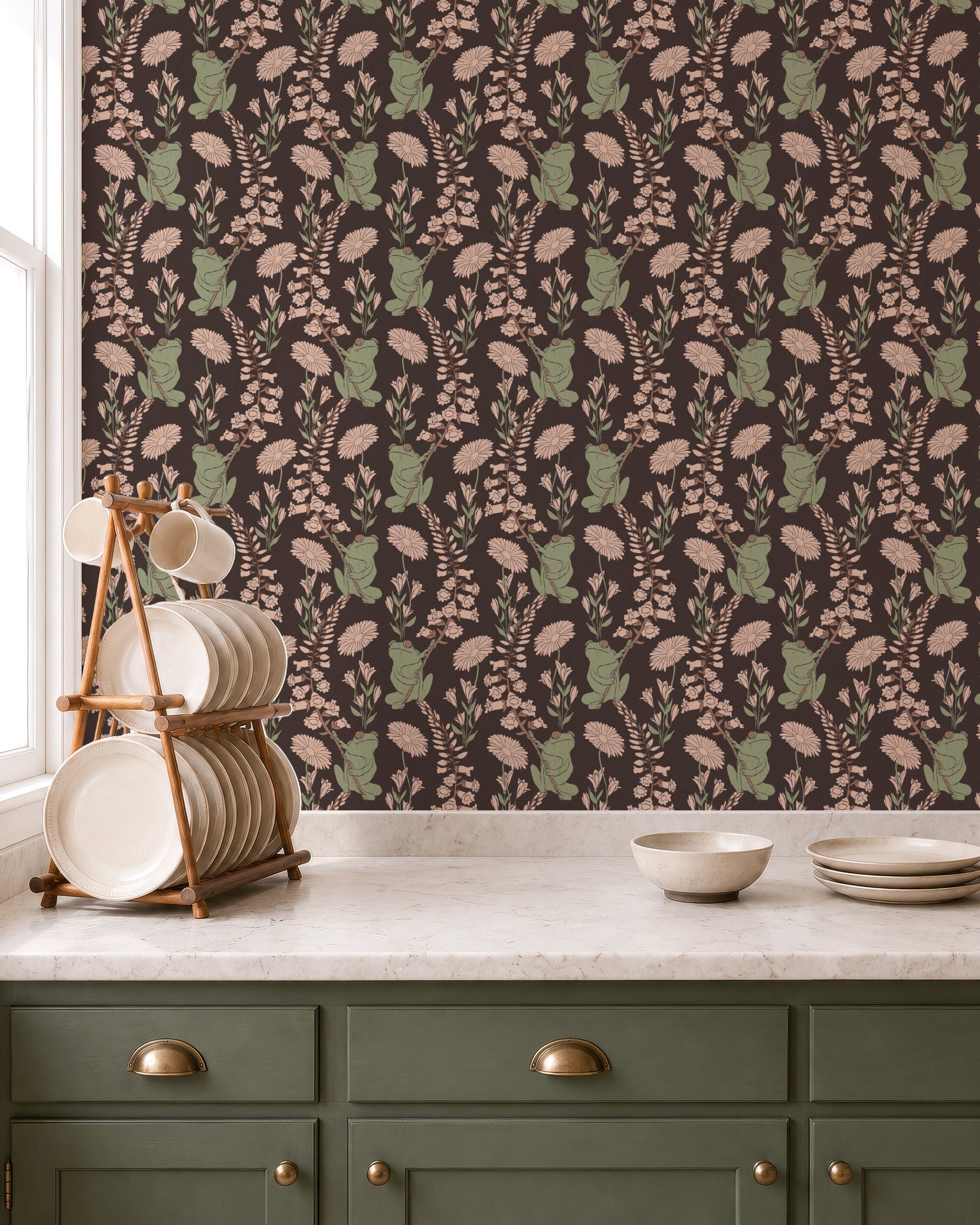 A kitchen scene featuring a dark brown wallpaper with a repeating pattern of muted green frogs and beige flowers. 