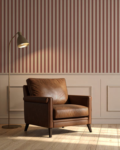 Brown leather armchair in a room with striped wallpaper and a floor lamp.
