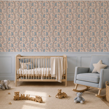 A styled nursery room featuring a wall covered in a beige and dusty blue frogs  wallpaper, with a light blue crib, matching rocking chair, and a light blue dresser.