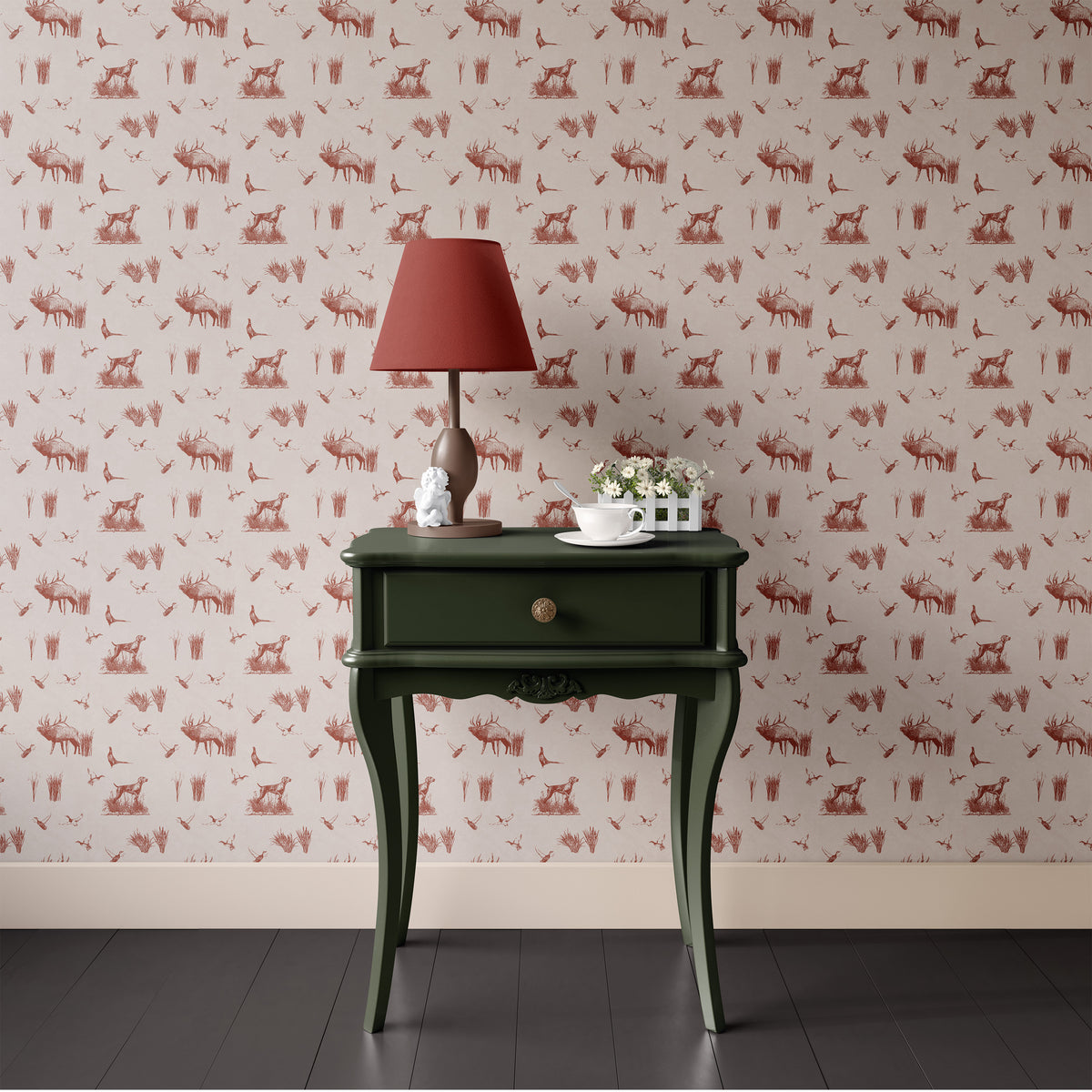Red hunting toile wallpaper behind a dark green bedside table and lamp