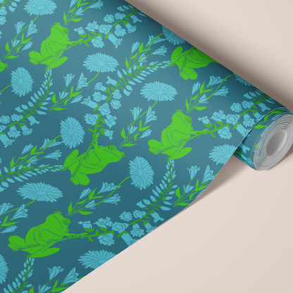 A roll of wallpaper with a green frogs and light blue wildflowers on a teal-blue background.