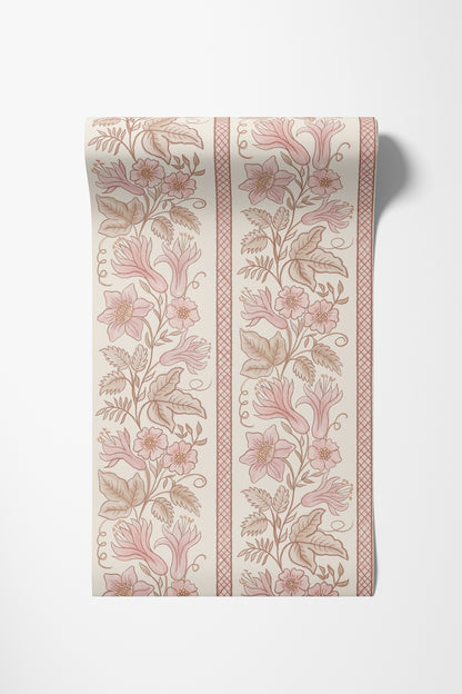 A roll of wallpaper with a girly  vintage botanical pattern featuring pink flowers and brown leaves on an off-white background, shown against a light gray wall.