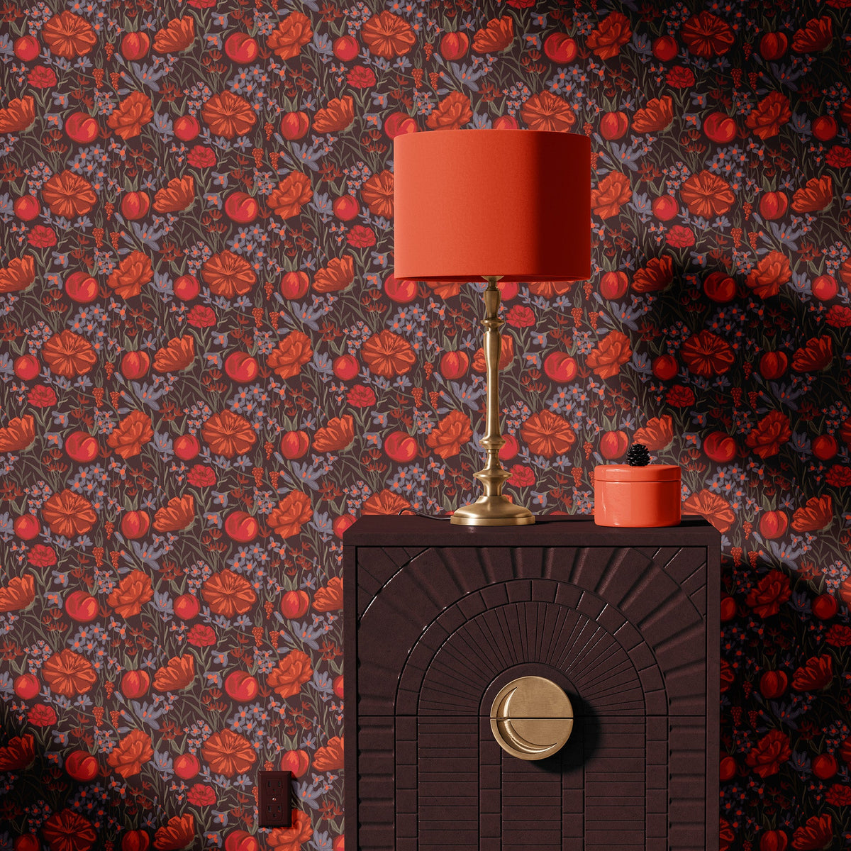 Dark brown and red floral wallpaper behind a dark cabinet and red table lamp
