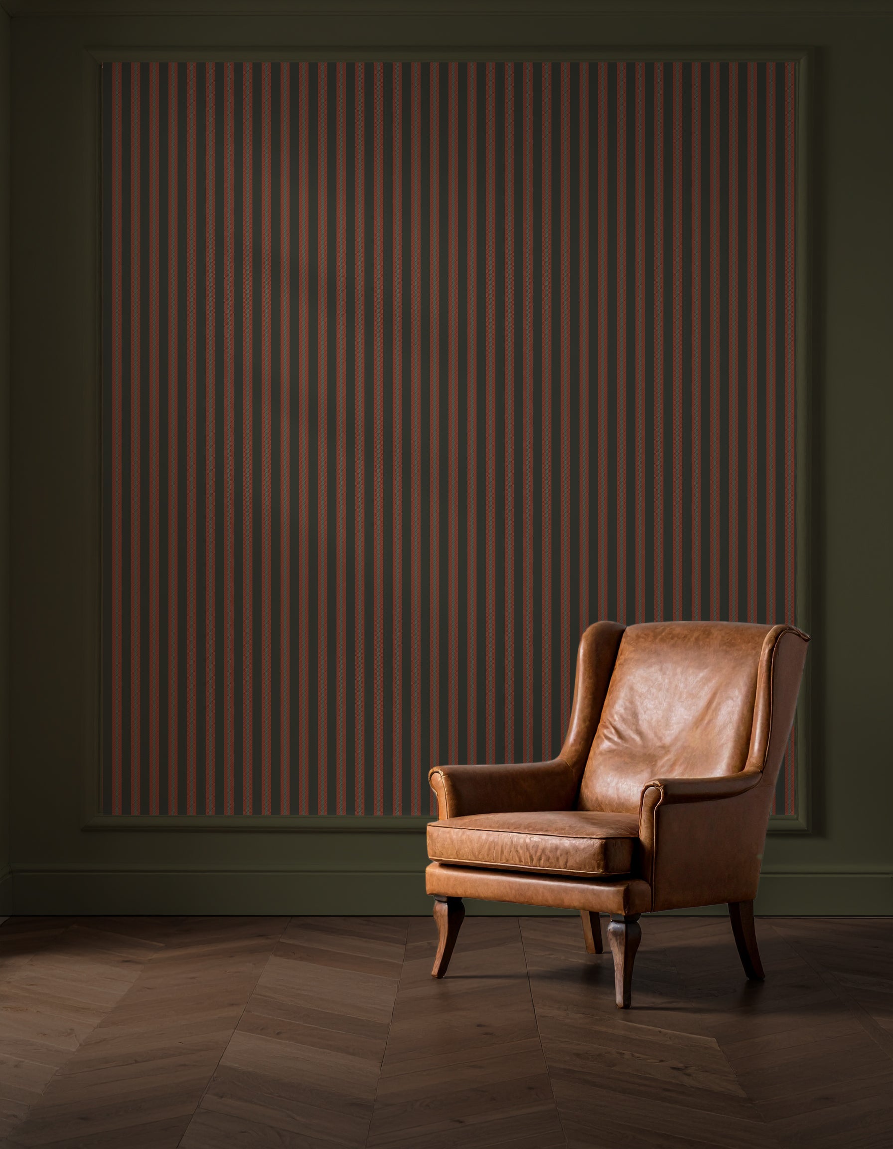 Brown leather armchair in a room with a striped wall and wooden floor.