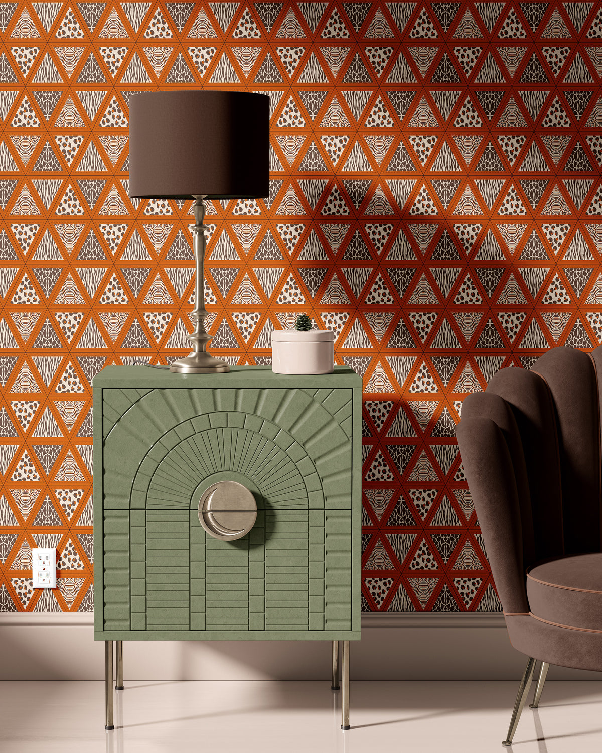 Terracotta safari animal print wallpaper behind a sage green cabinet and table lamp