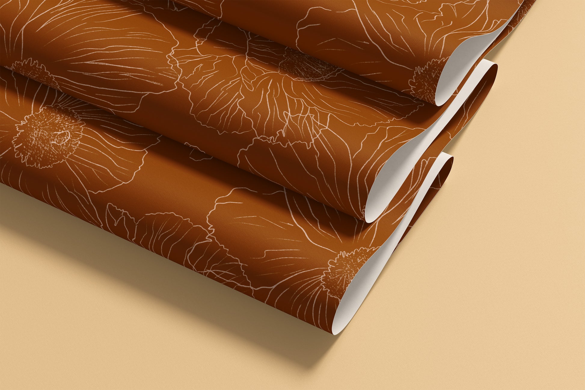 rolled sheets of terracotta patterned wallpaper with a light beige floral line design