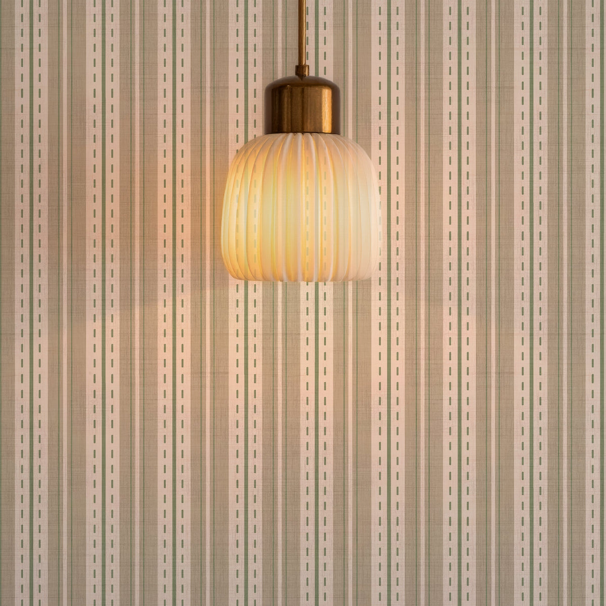 Ticking stripe wallpaper behind a table lamp