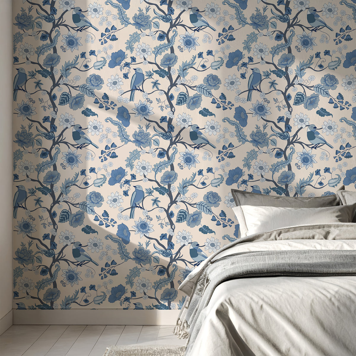 Blue tree of life wallpaper behind a bed with gray linen