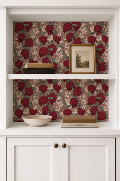 A white built-in shelving unit with a pomegranate pattern wallpaper on the back panel. The shelves display decorative items including a small framed landscape print, books, and a ceramic bowl.